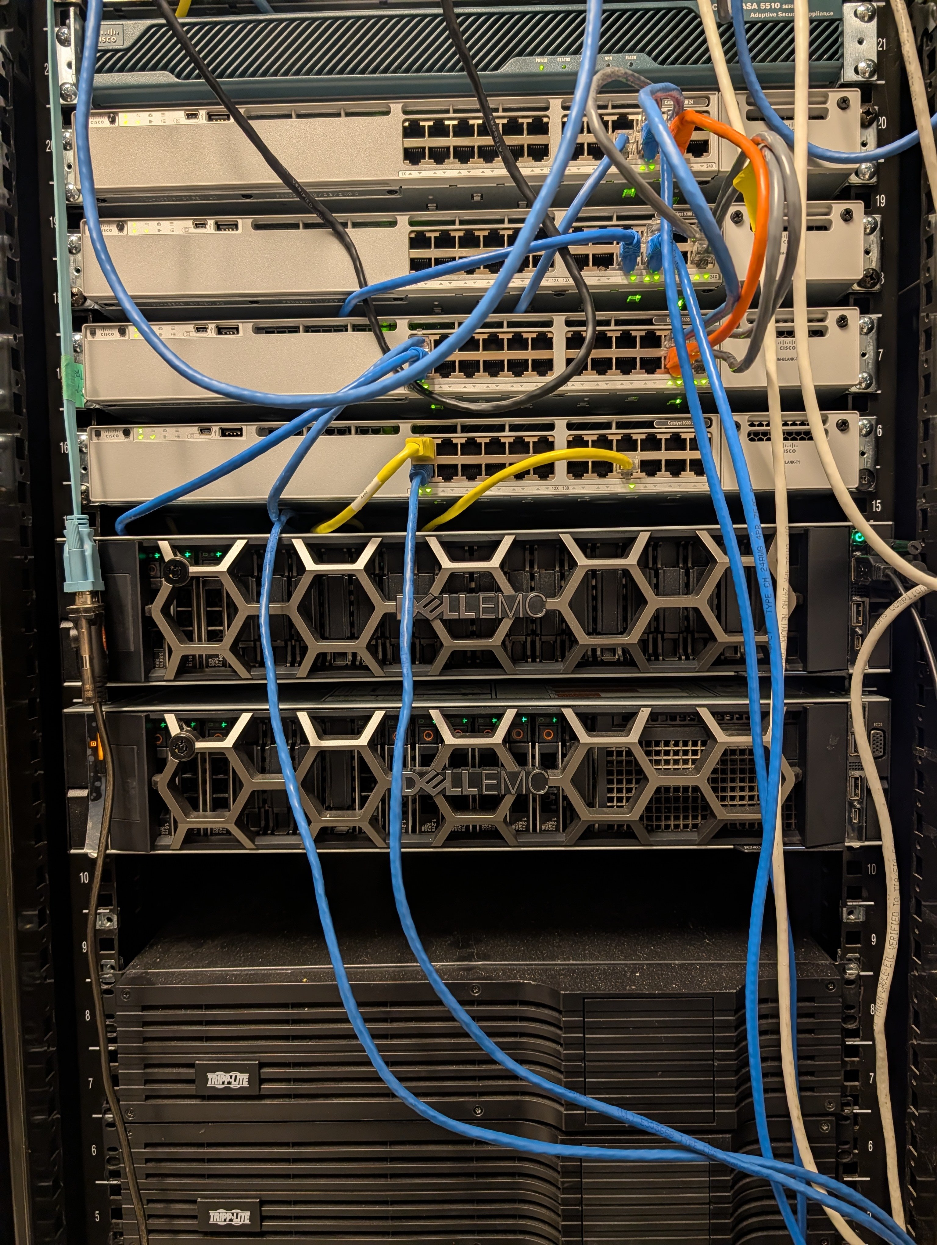 Rack-mounted Cisco switches, security appliance, and Dell EMC servers used in LaneCert lab training.